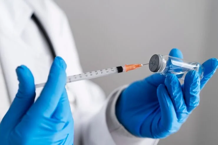 side-view-doctor-holding-syringe-vial_23-2149310006