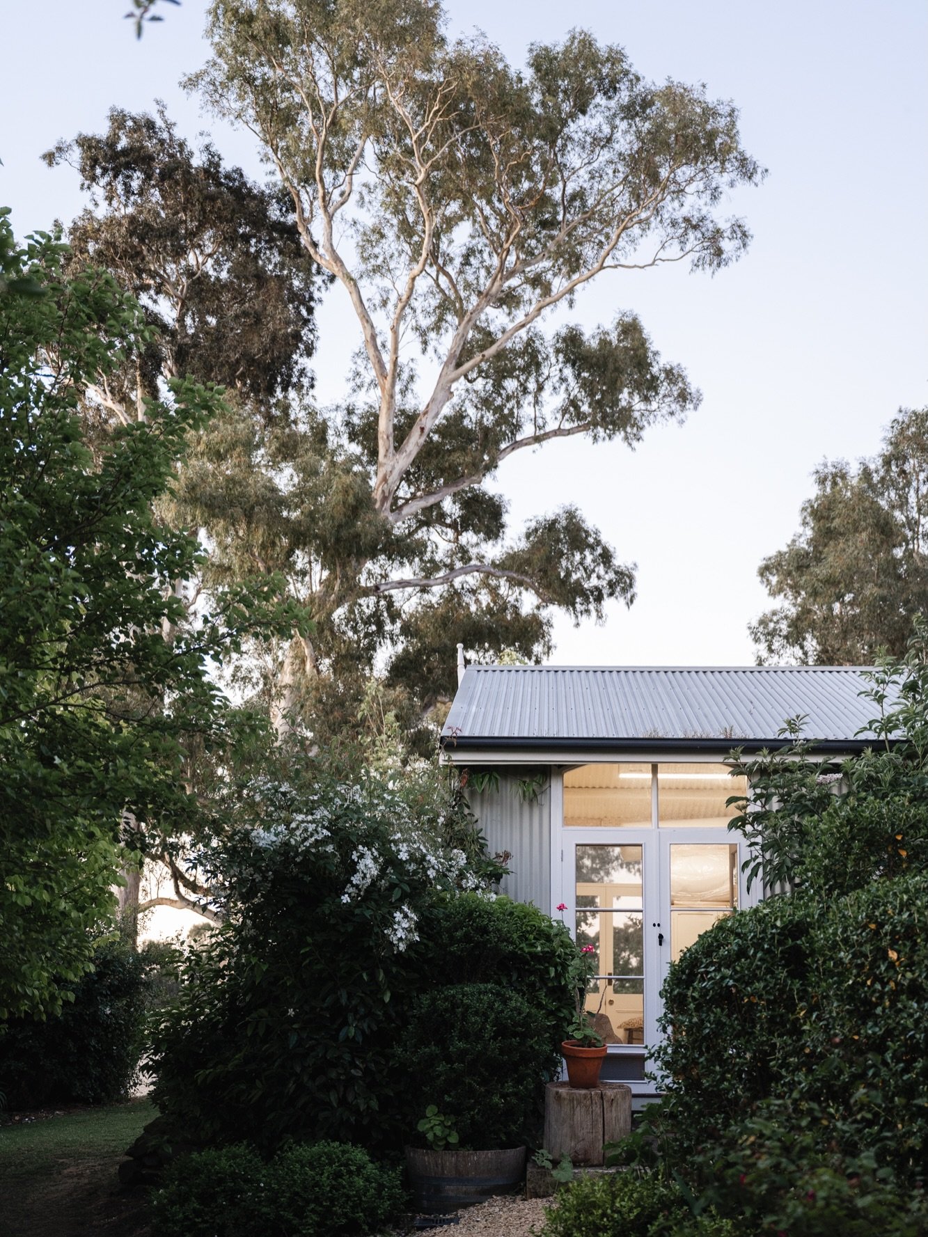 Framed by a white rambling rose in full bloom, a set of traditional French doors provides a warm welcome into the artistic retreat of a painter who translates garden memories into dreamscapes. Away from the distractions of everyday life, a connection
