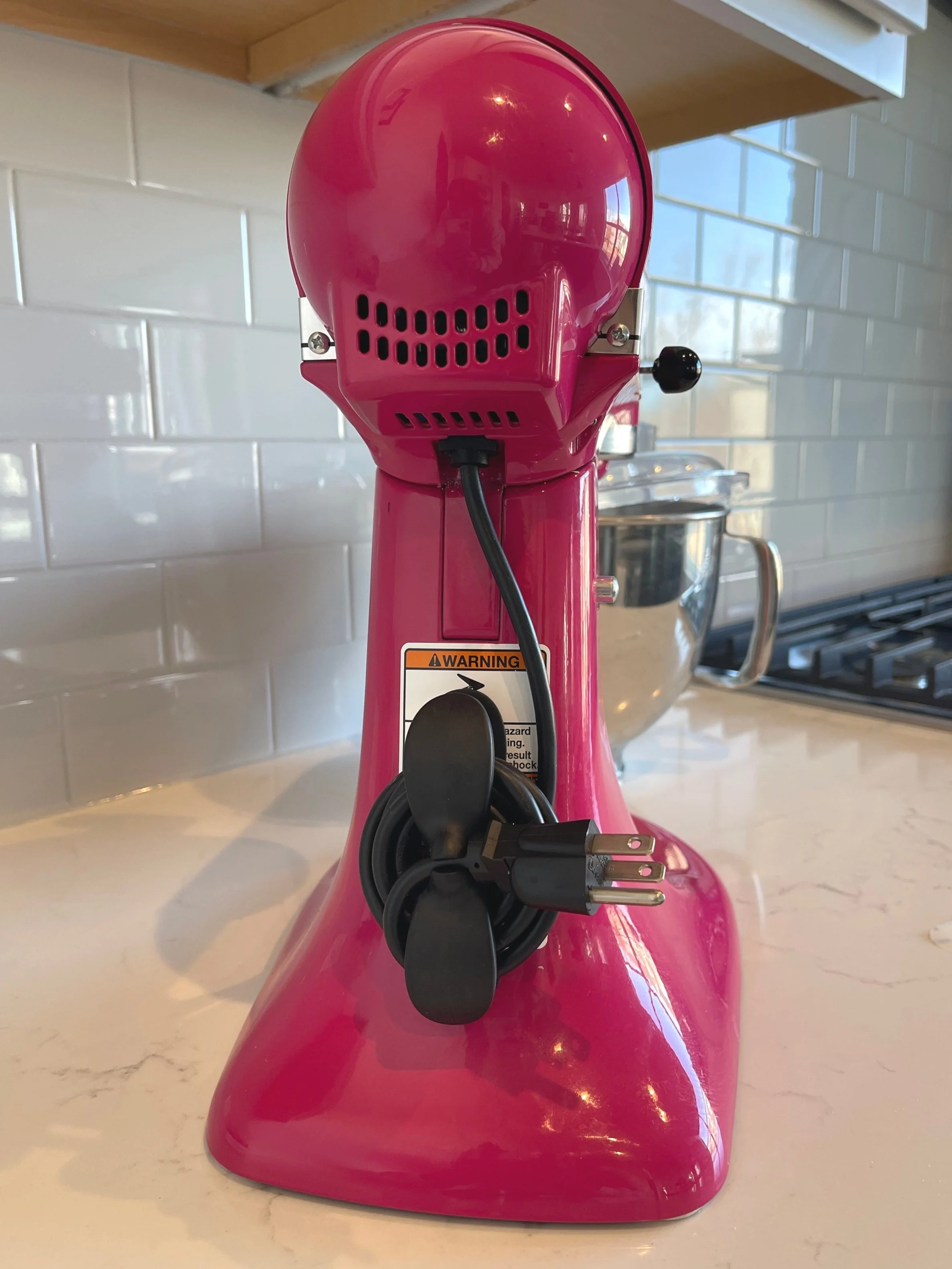 Adhesive cord organizer attached to a small kitchen appliance to neatly store the power cord.