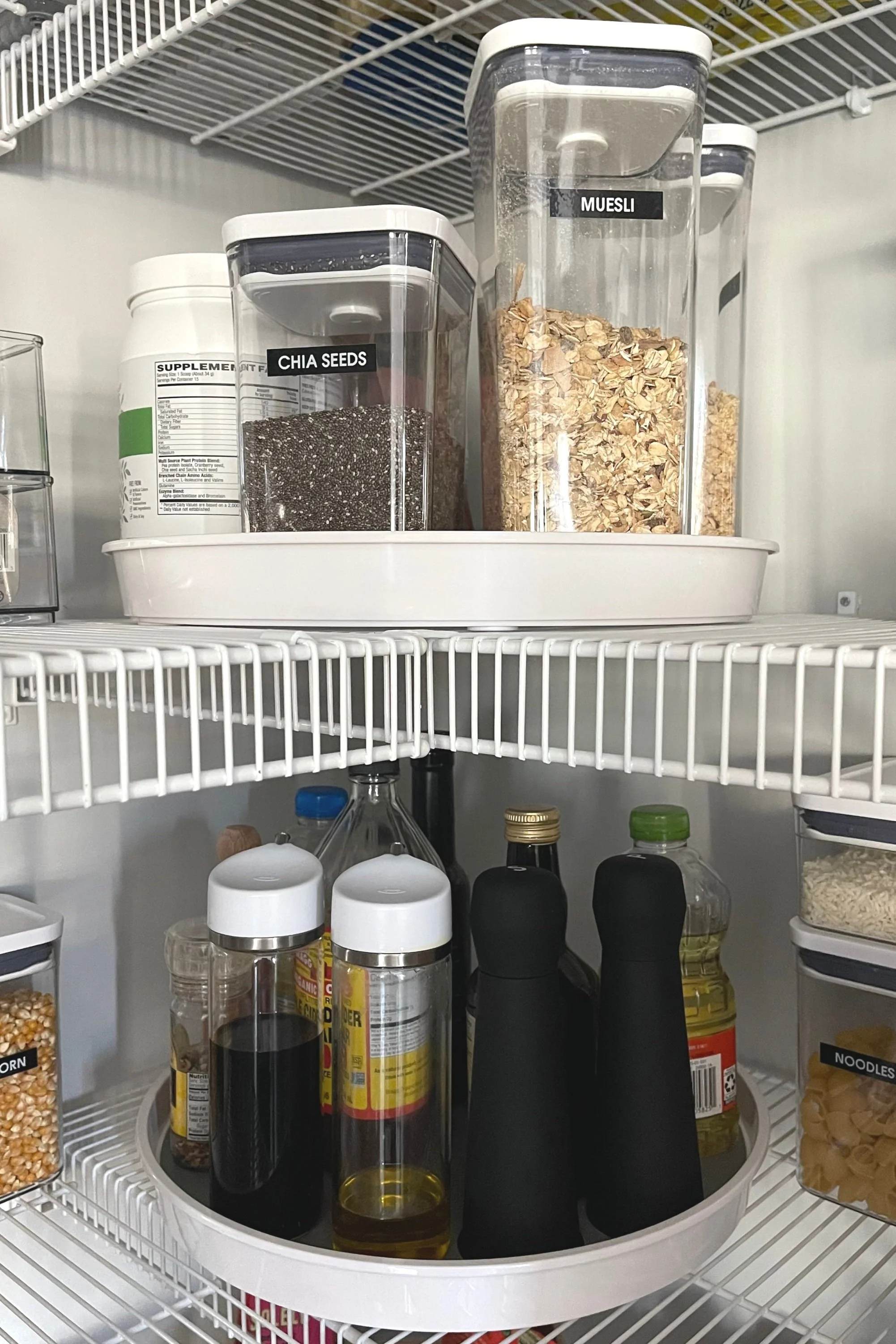 Corner pantry organized with two large turntables for easy access to oils, condiments, and pantry essentials.