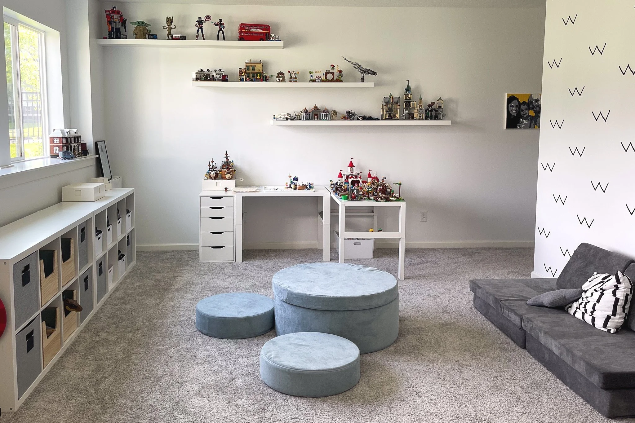 Organized LEGO playroom with display shelves, building space, and storage solutions for finished sets and loose bricks.