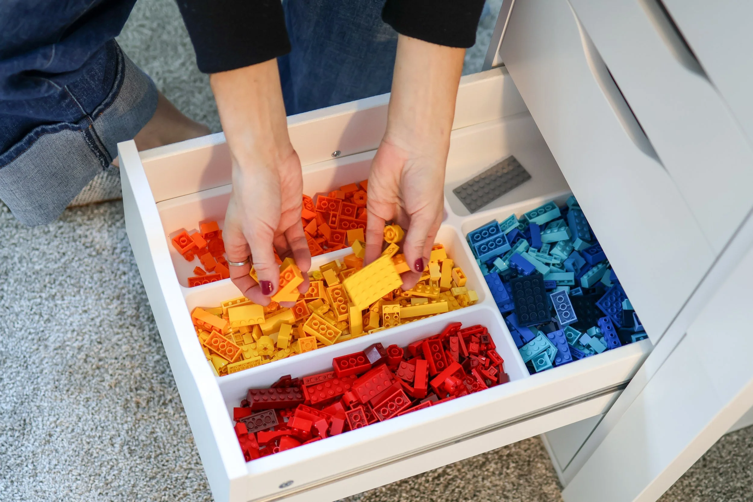 LEGO bricks organized in an IKEA ALEX drawer unit with drawer organizers for easy sorting and cleanup.