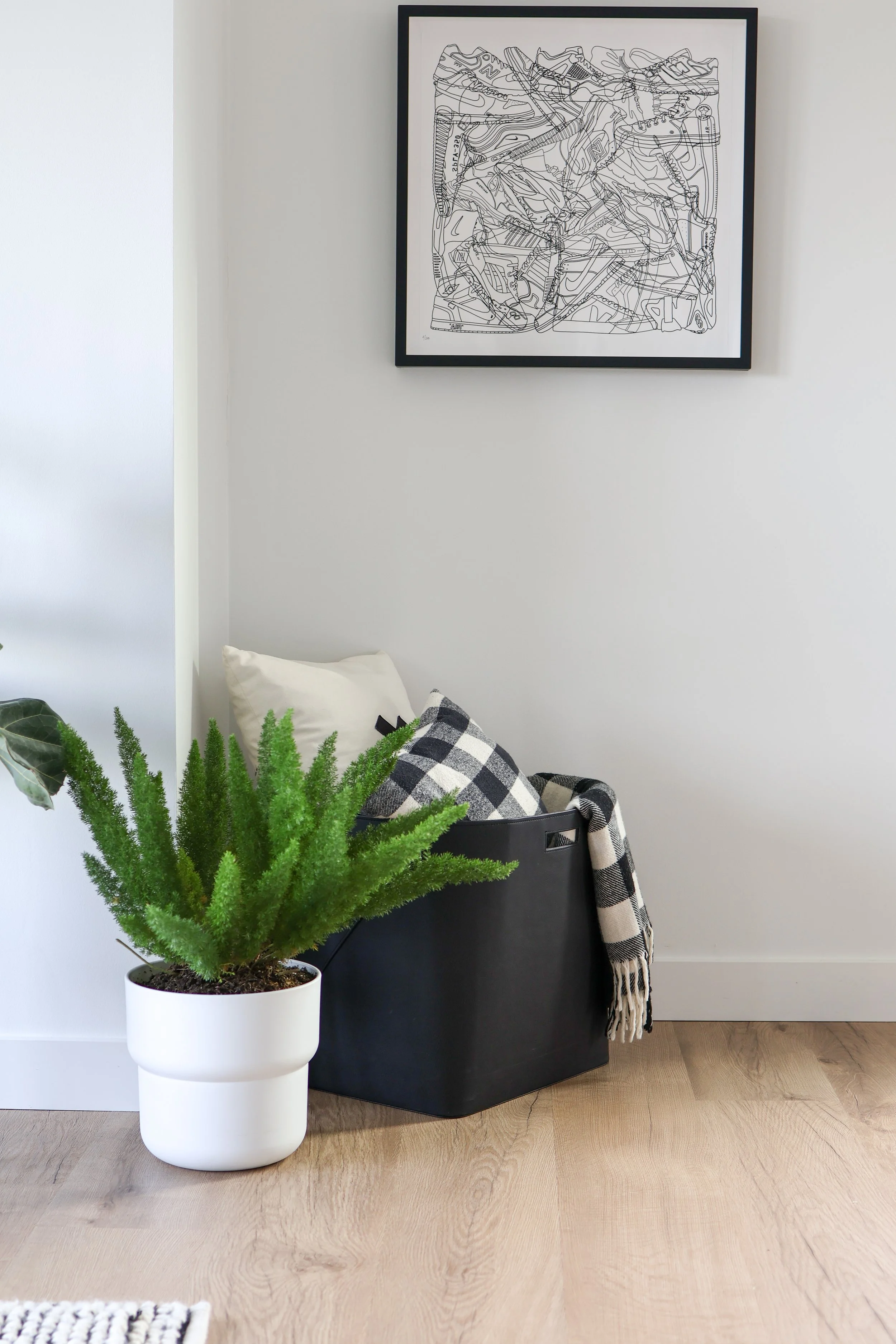 Decorative storage bin with pillows and a plant, representing a calm, organized home.