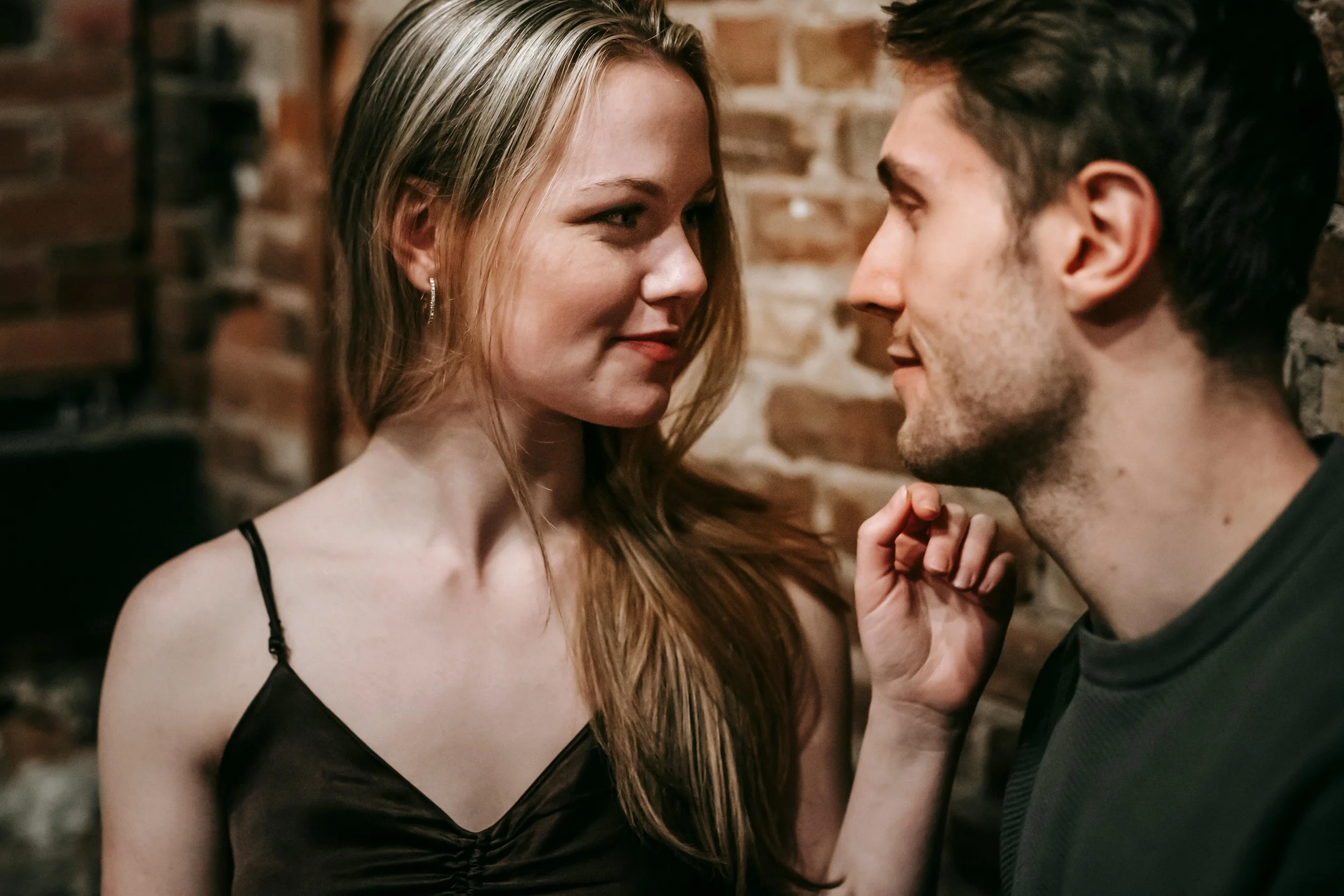 a man and woman are staring deep into each others eyes, smiling slightly