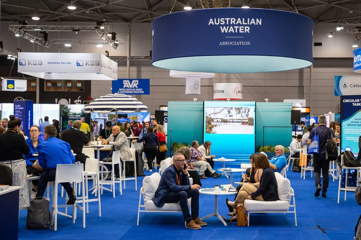 Delegates networking within the Ozwater'26 conference exhibition area at Brisbane Convention & Exhibition Centre.