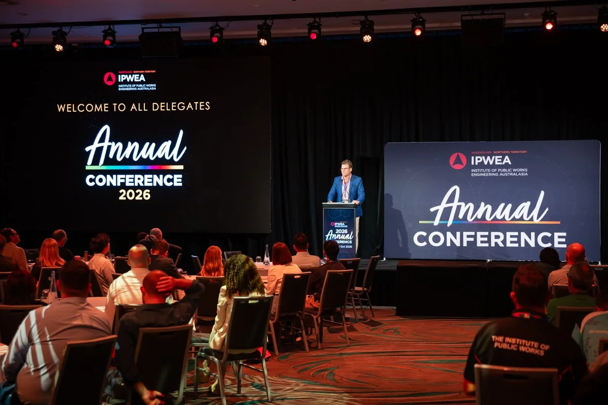 Conference MC (Richard Champion) on stage speaking to delegates at the IPWEA-QNT Annual Conference 2026, held at the Sunshine Coast Convention Centre, Novotel Sunshine Coast Resort.