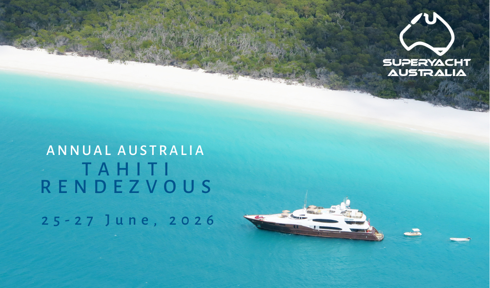 An aerial view of a large yacht anchored in turquoise water near a white sandy beach with lush green forest in the background. Overlayed text advertises an event in Tahiti, Australia, from June 25-27, 2026, hosted by SuperYacht Australia.
