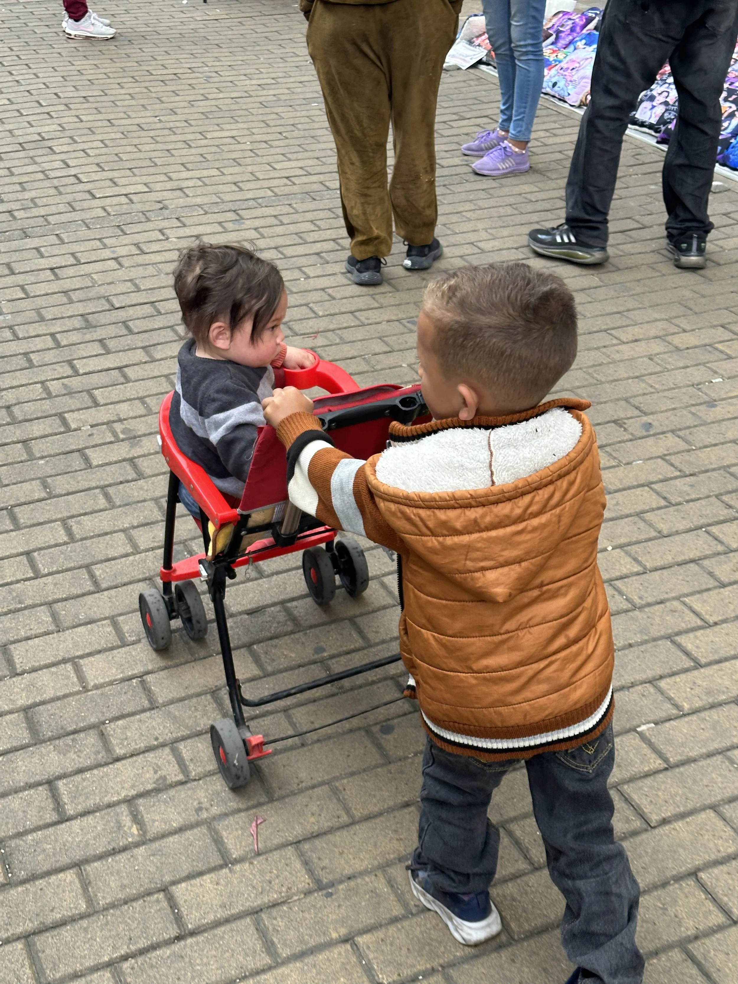 young dude is pushing his little sister