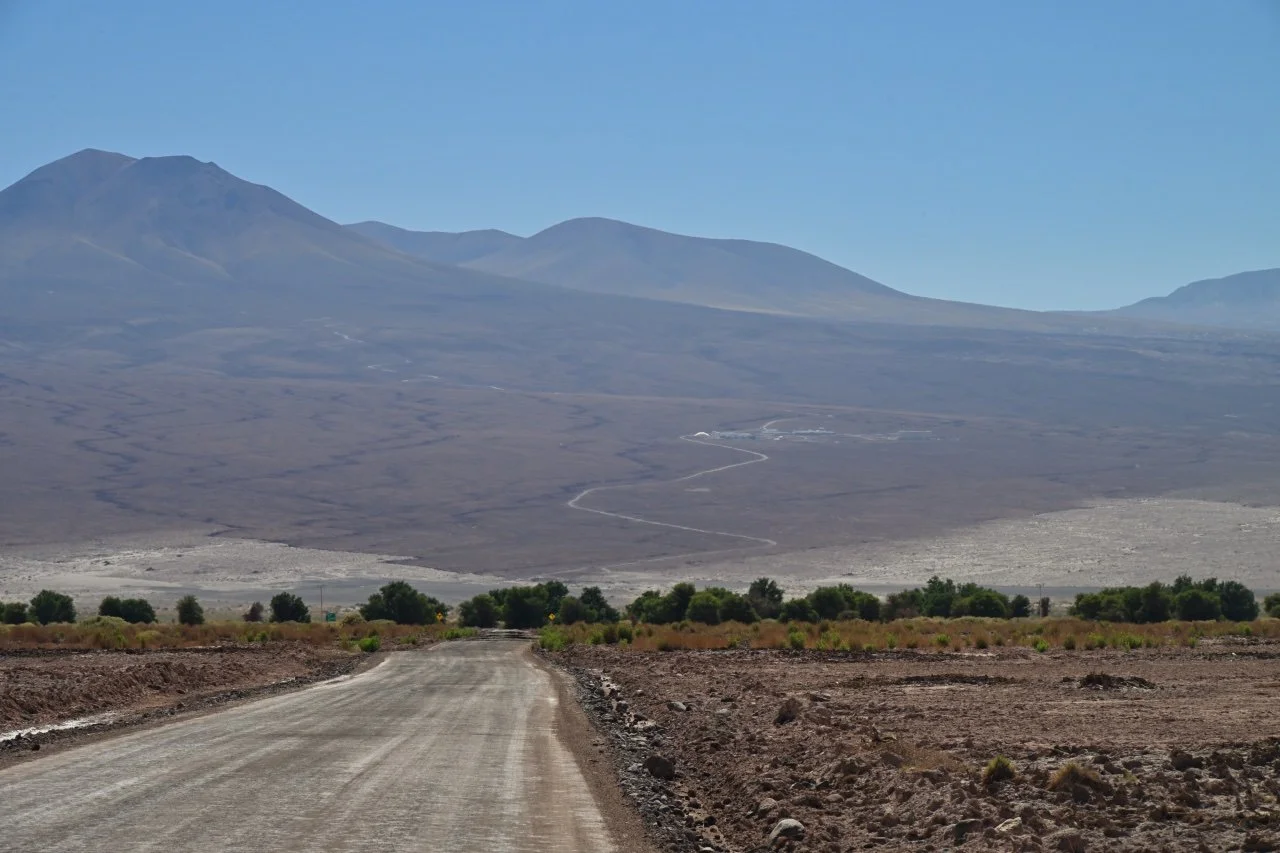  road to one of the space observatory. The buildings in the middle are the support facilities, the array of telescopes are in the saddle behind the mountains.