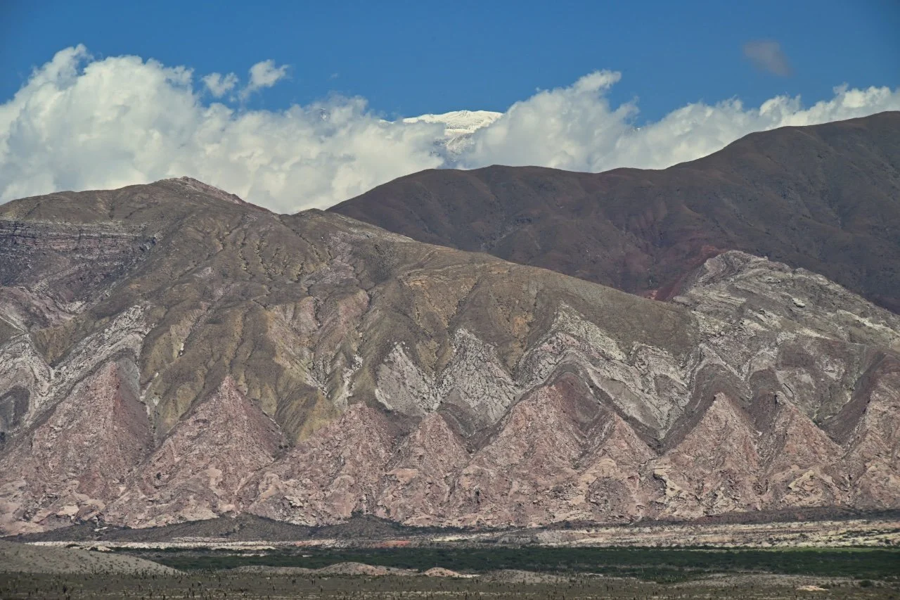  colour mountain with a snowy peak in the middle behind them