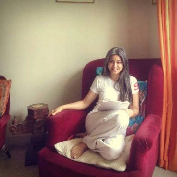 Person sitting on a red armchair reading a paper