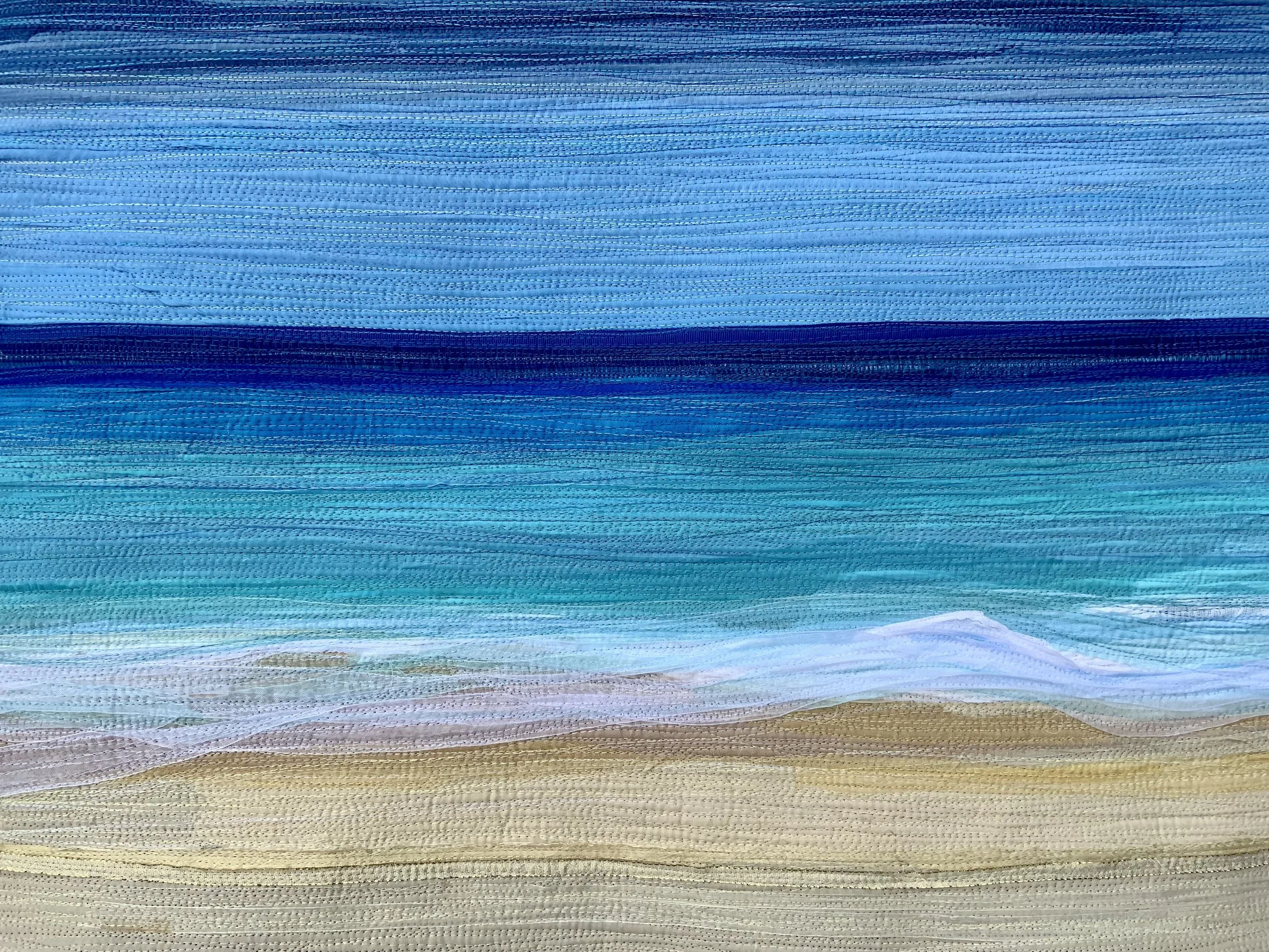 Ocean-themed abstract textile artwork with horizontal layers of blue and beige