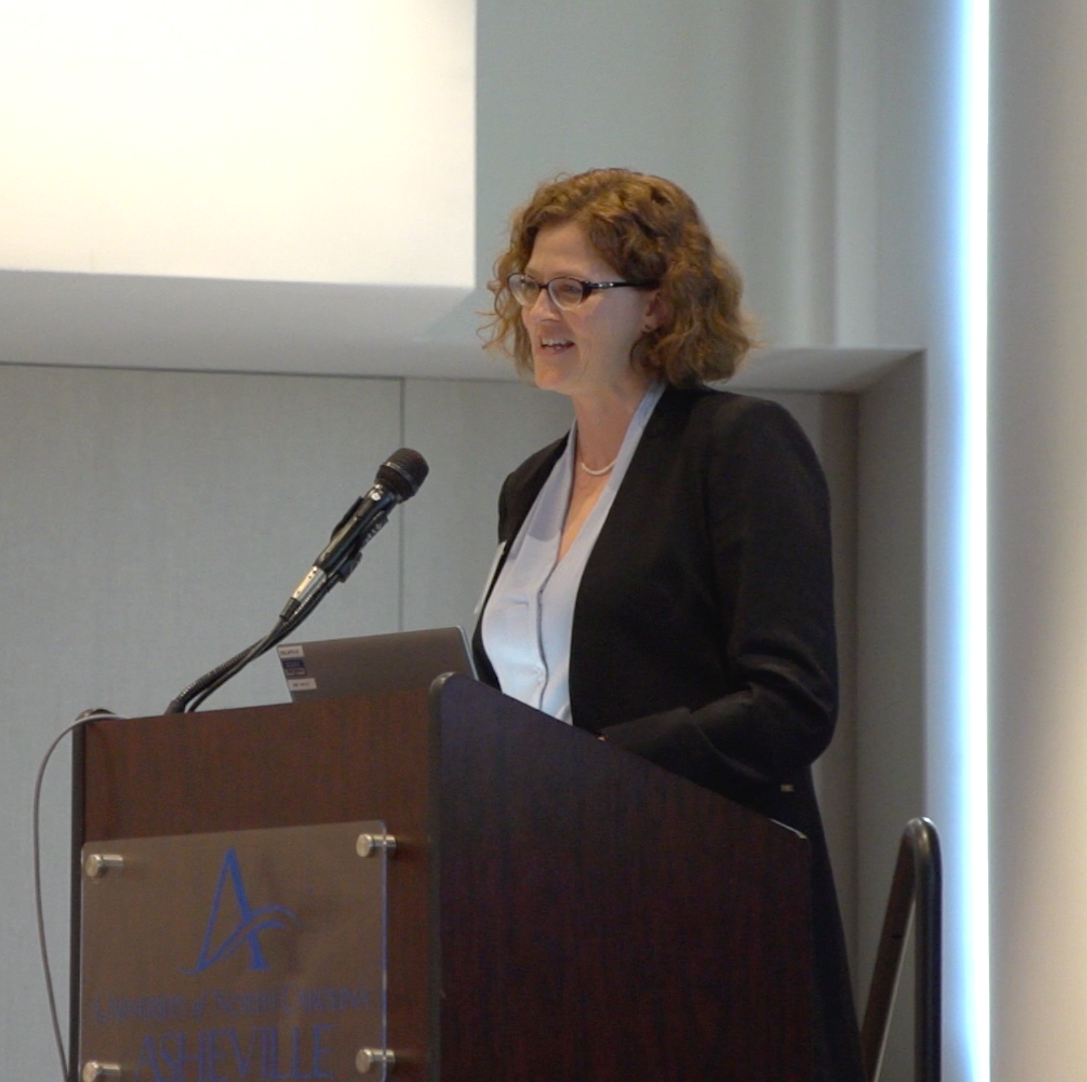 Laurie Stradley (CEO, Impact Health) delivers keynote address “Transforming for Resilience: How Western North Carolina is Reimagining Rural Health.” Close-up. Photo credit: Andrew Rainey, NC Center for Health and Wellness