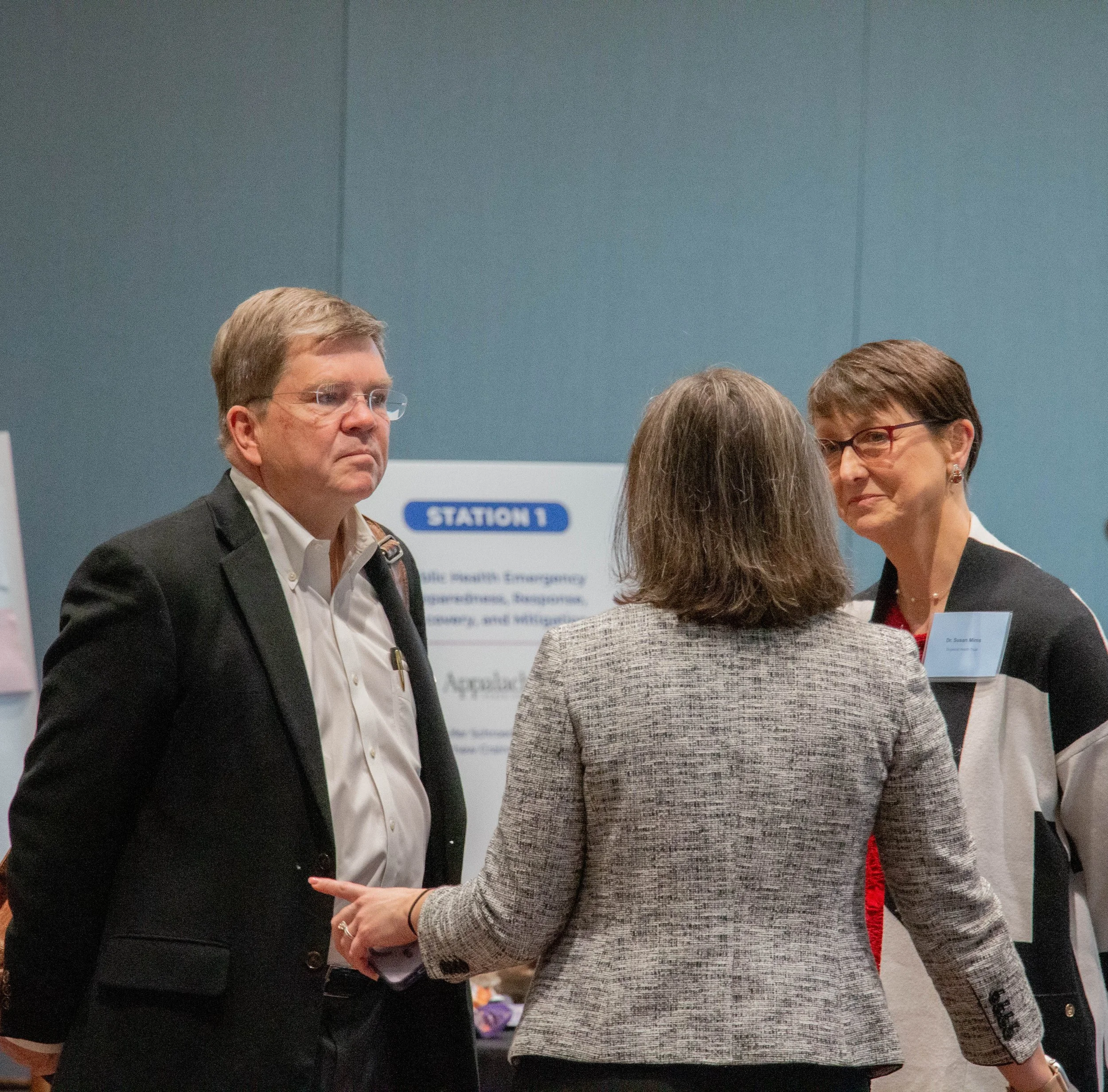 Dr. Bill Hathaway and Dr. Susan Mims speak with attendee. Photo credit: Michaela Lumpert, Impact Health
