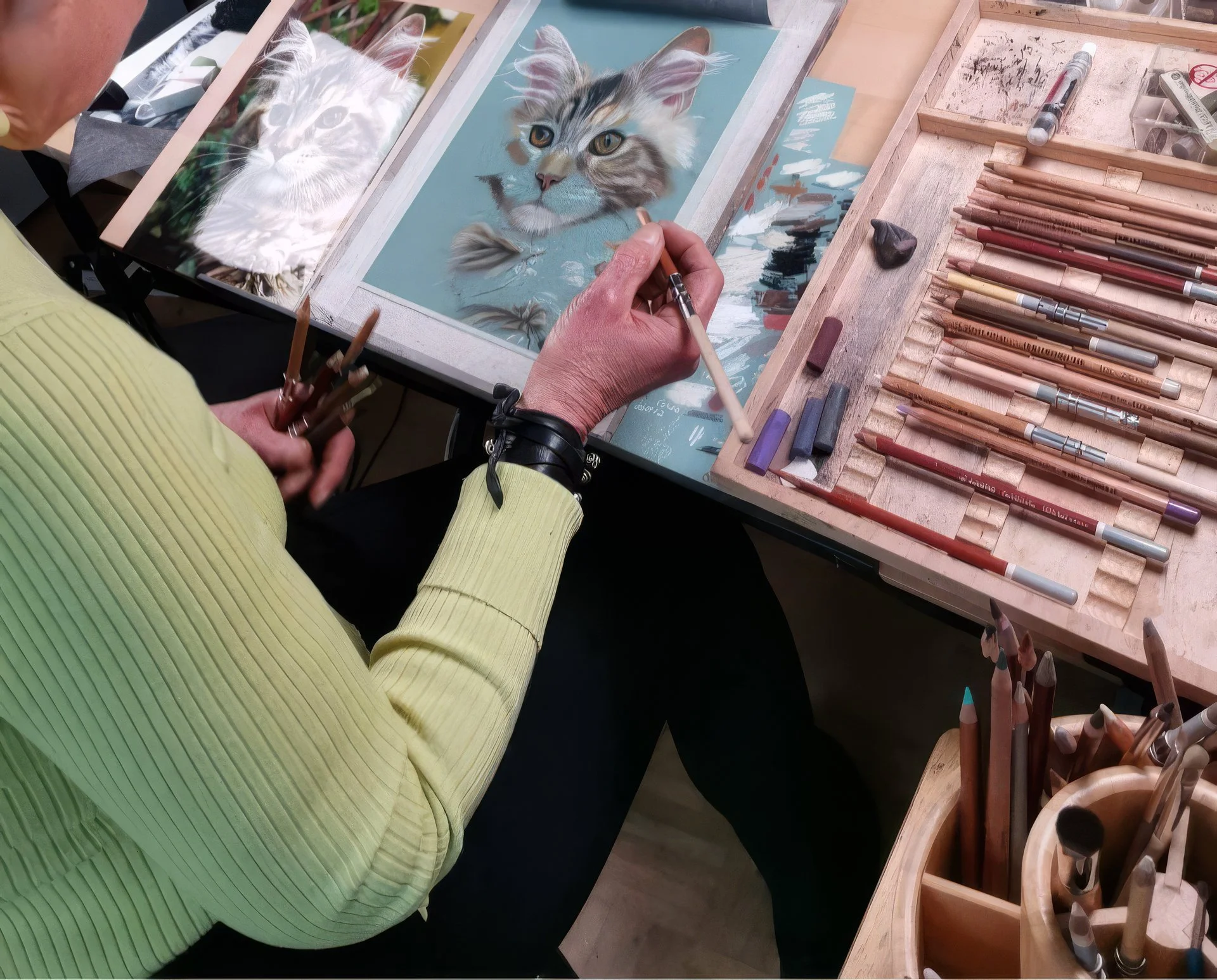 Eine Frau ist im Atelier und zeichnet eine Katze fotorealistisch.