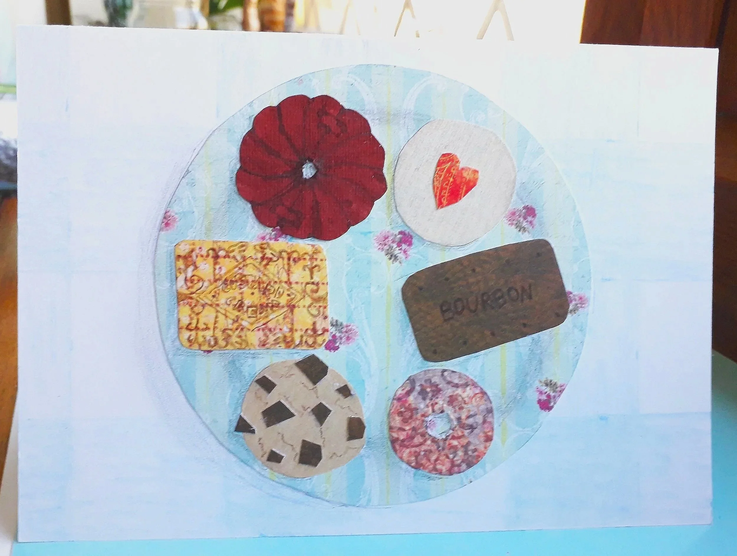 A handmade card depicting a blue plate of six assorted biscuits