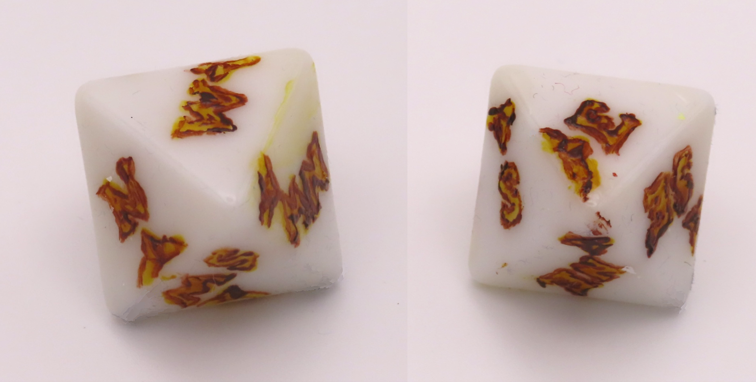 Two images of an eight-sided die, each face painted with letters representing one of the eight compass points