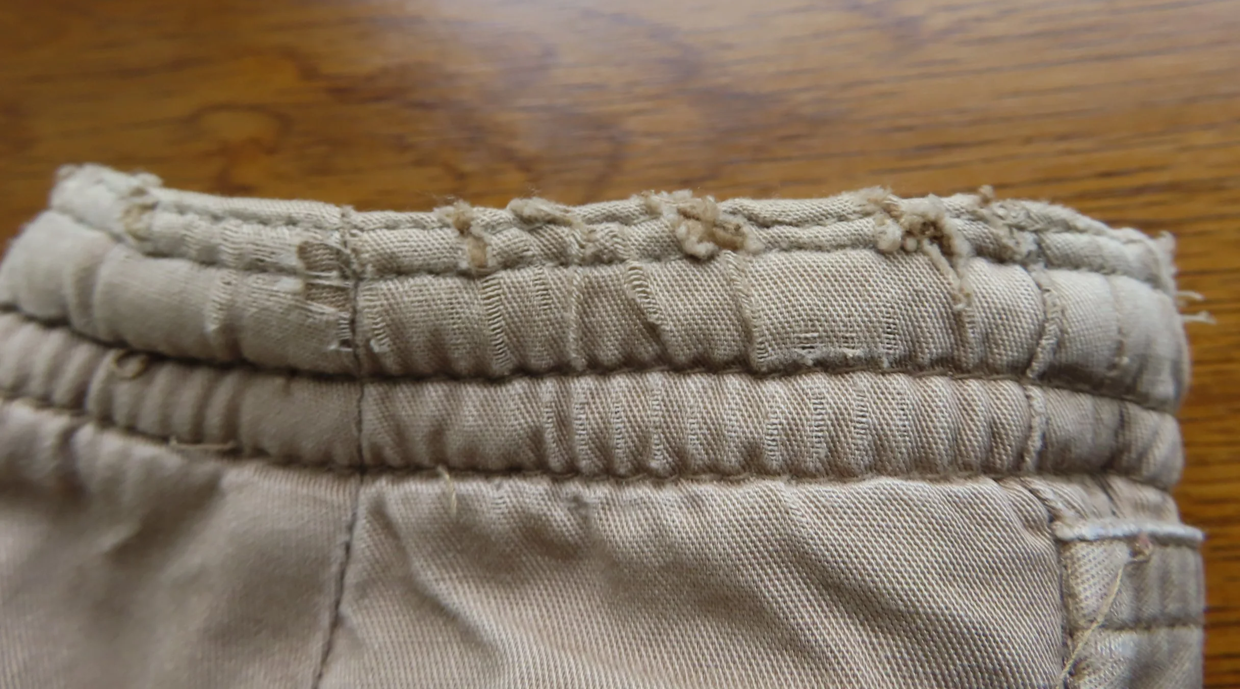 The tattered edge of a brown coat sleeve