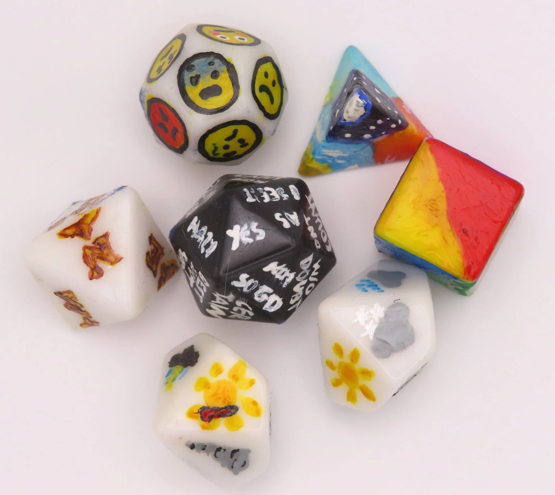 A set of dice of various shapes, with faces showing various words, colours and symbols