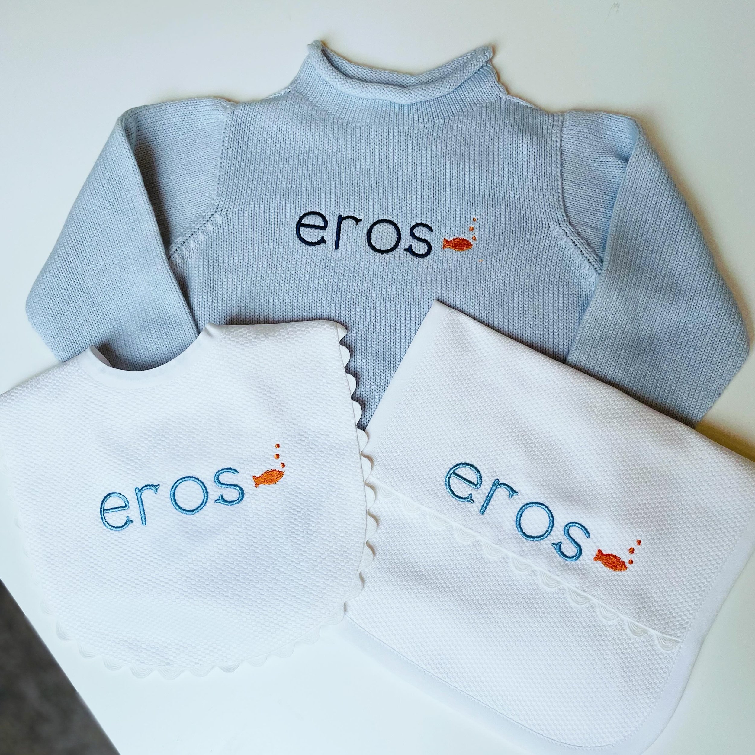 Loving this little fish-themed bundle for a new baby boy &mdash; our fan-favorite rollneck sweater and white pique cotton bin &amp; burp cloth set!  And how fun is the blue &amp; orange combo?! 🐟🧡