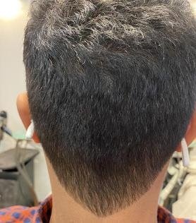 Back of a person's head showing a fresh fade haircut with darker hair on top and a lighter, tapered back.