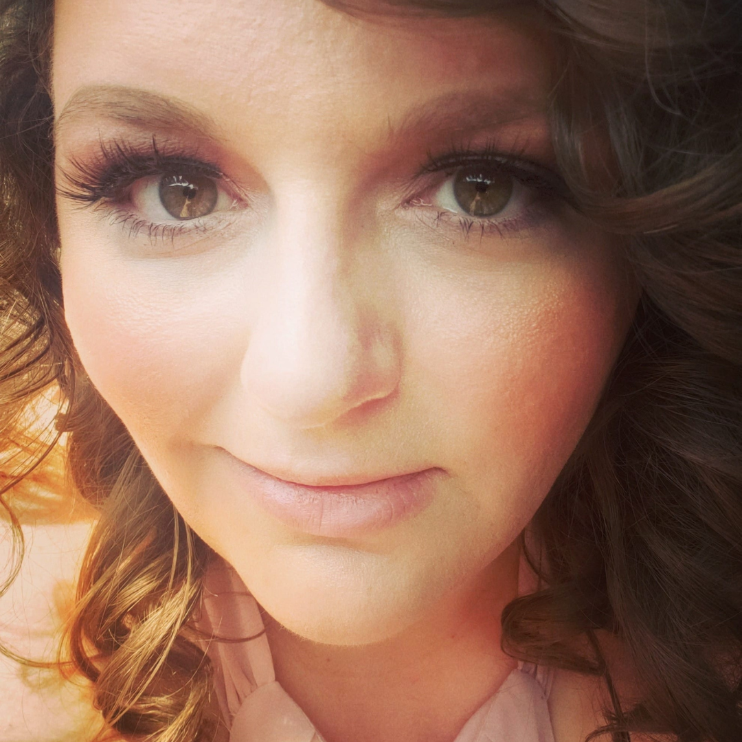 Close-up of a woman's face with makeup and curly hair