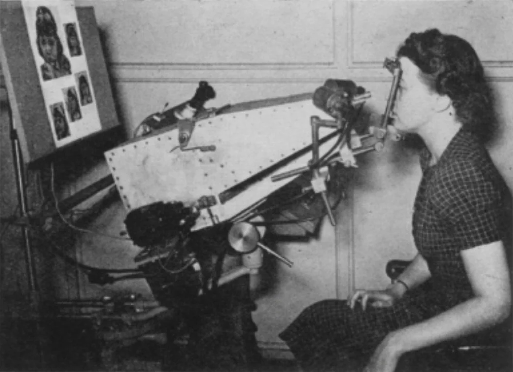 A woman using an eye-tracking device, vintage setup, black and white.