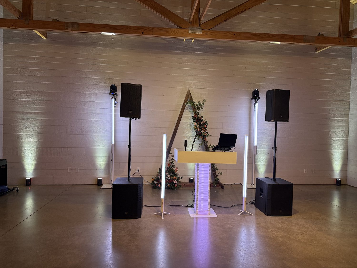 DJ and lighting setup in a wooden event hall.