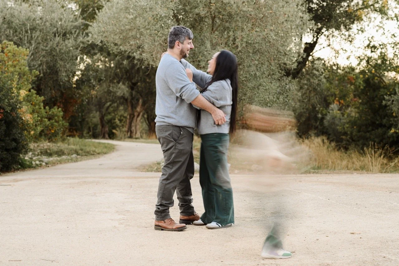 Un moment tendresse d'un couple alors que l'enfant court autour d'eux dans un parc