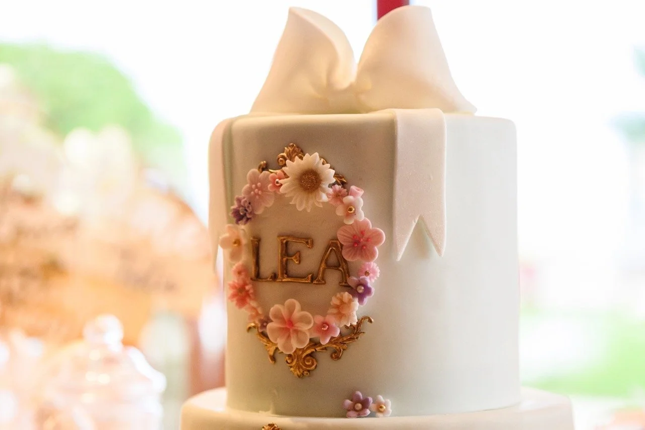 Gâteau blanc décoré avec une couronne de fleurs en relief pour un joli baptême