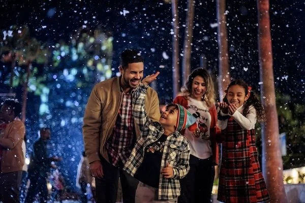 Family walking through Disney's Hollywood Studios with snow falling all around them
