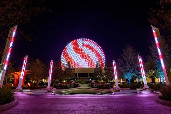 Spaceship Earth at EPCOT in a red and white candy cane light display for the Christmas holidays