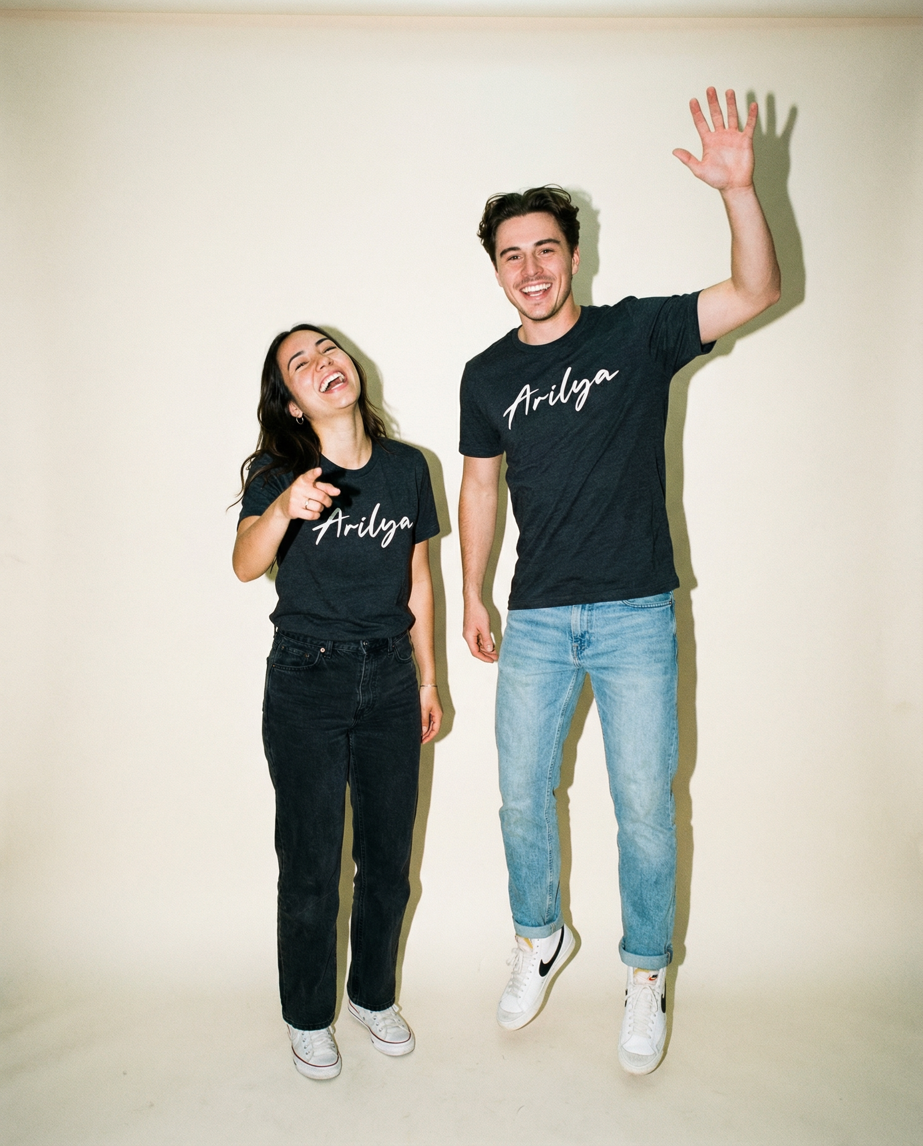 Arilya Logo T-Shirt Oliver Ade both guy and girl wearing the Arilya Logo T-Shirt. Full body fun pose.png