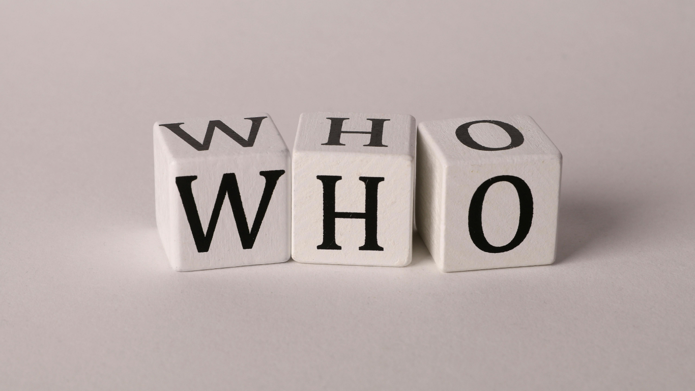 Three white cubes with black letters spelling out 'WHO' on a light background.