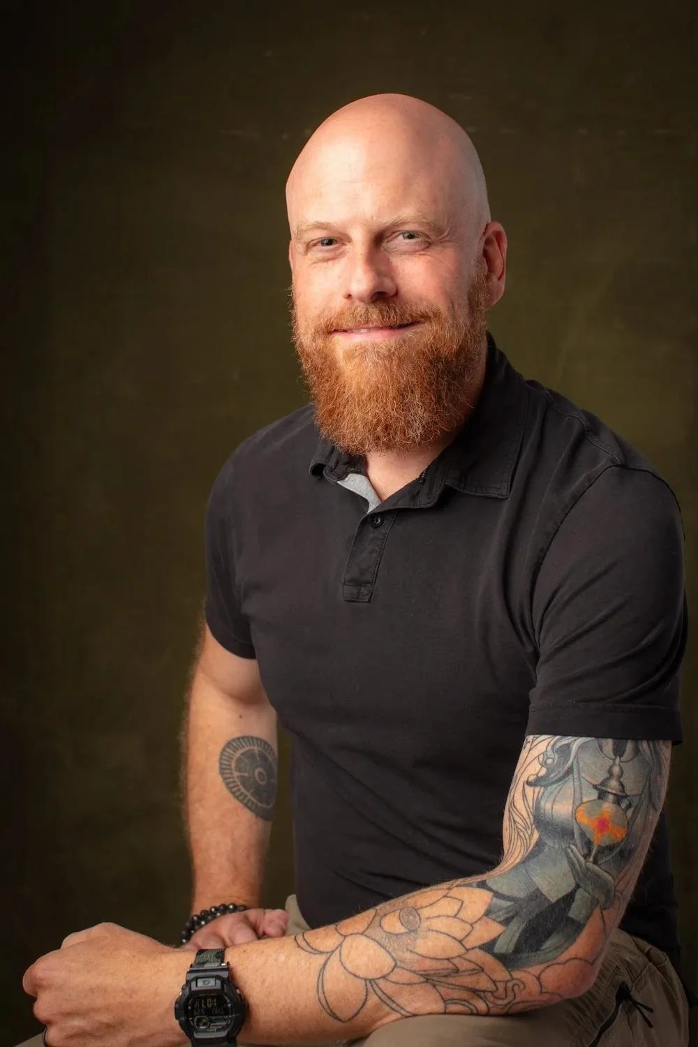 Nicholas Whitaker sitting on a chair and a black background