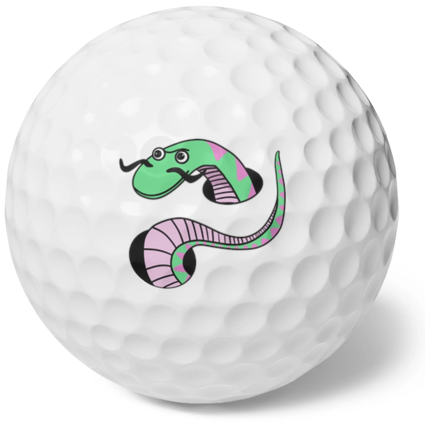 Close-up of a golf ball with a cartoon snake graphic on it.
