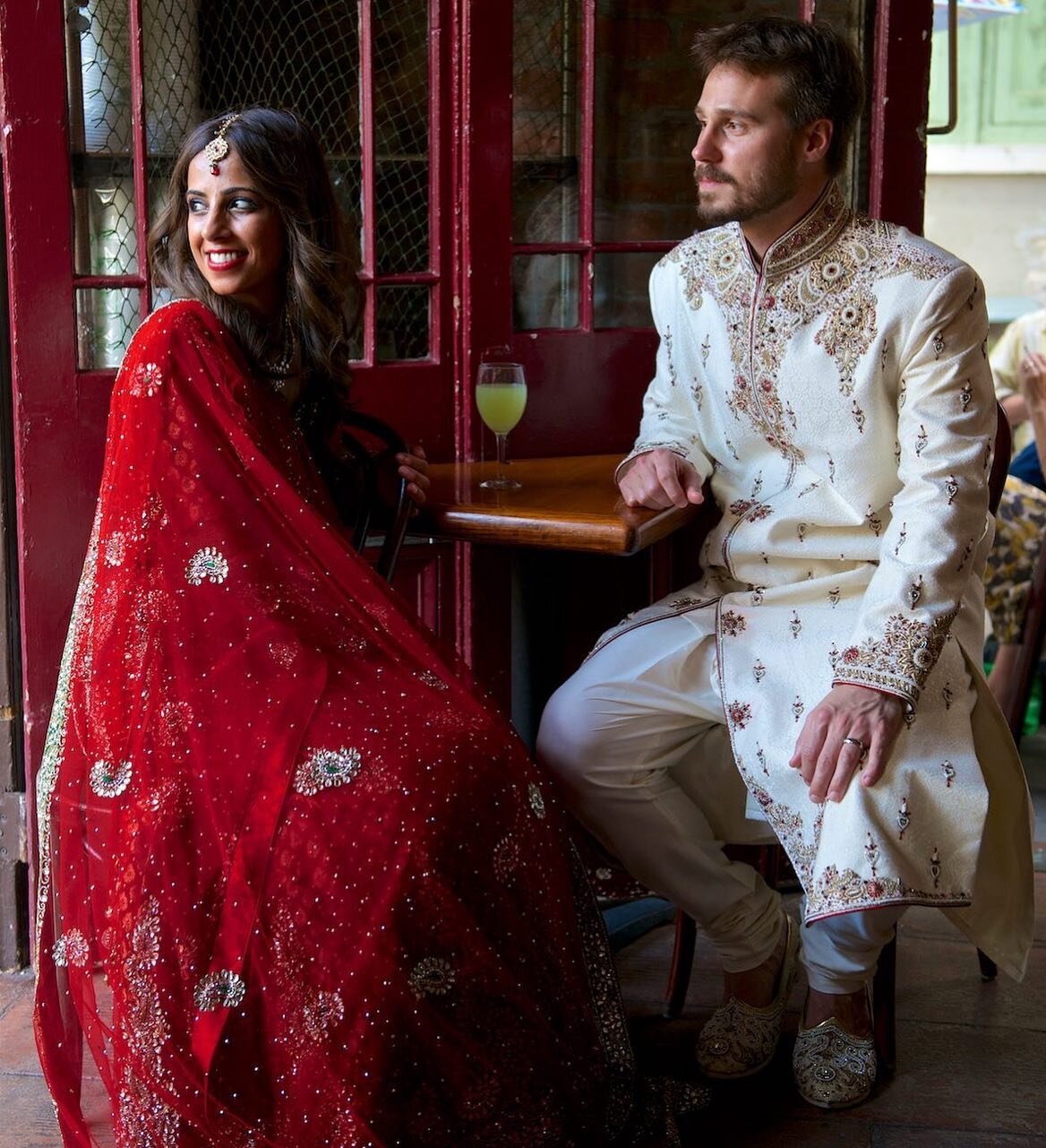 Image by @marcpaganiweddings - paganiphoto.com. Shivani and Matt share a drink at a bar in Pirate&rsquo;s Alley before their wedding in New Orleans. #weddings #kiss  #love #weddingchicks #weddingphoto #marriage #portrait #weddingportrait #bride #brid