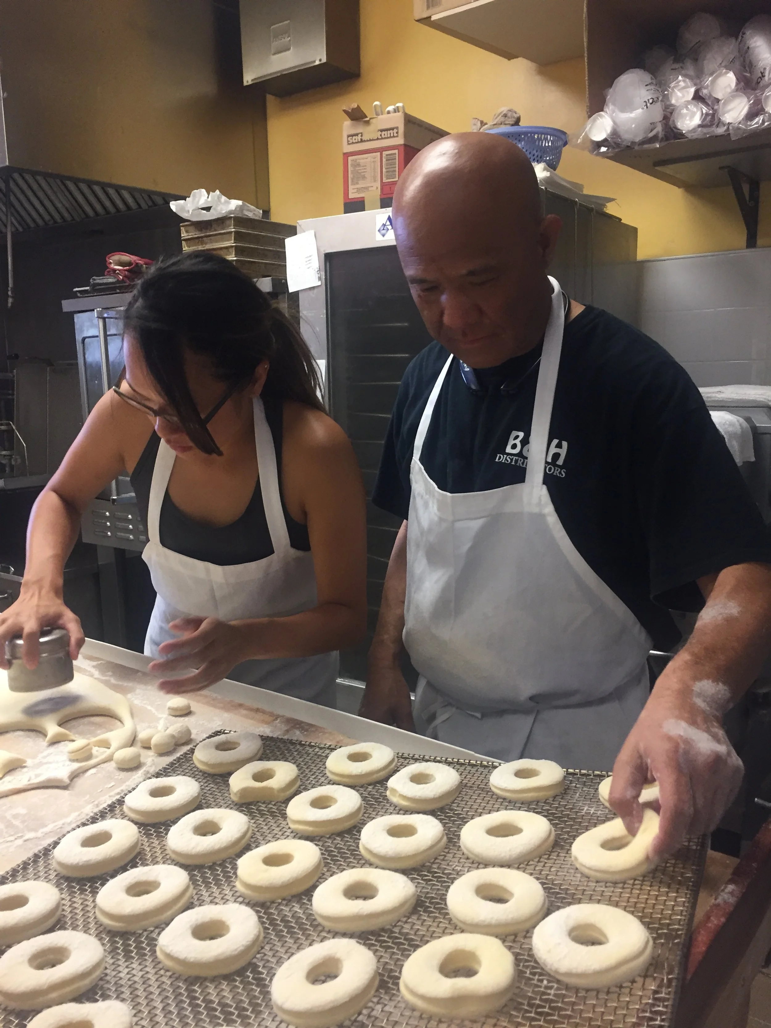 Robert Chau and his daughter making donuts in his donut shop