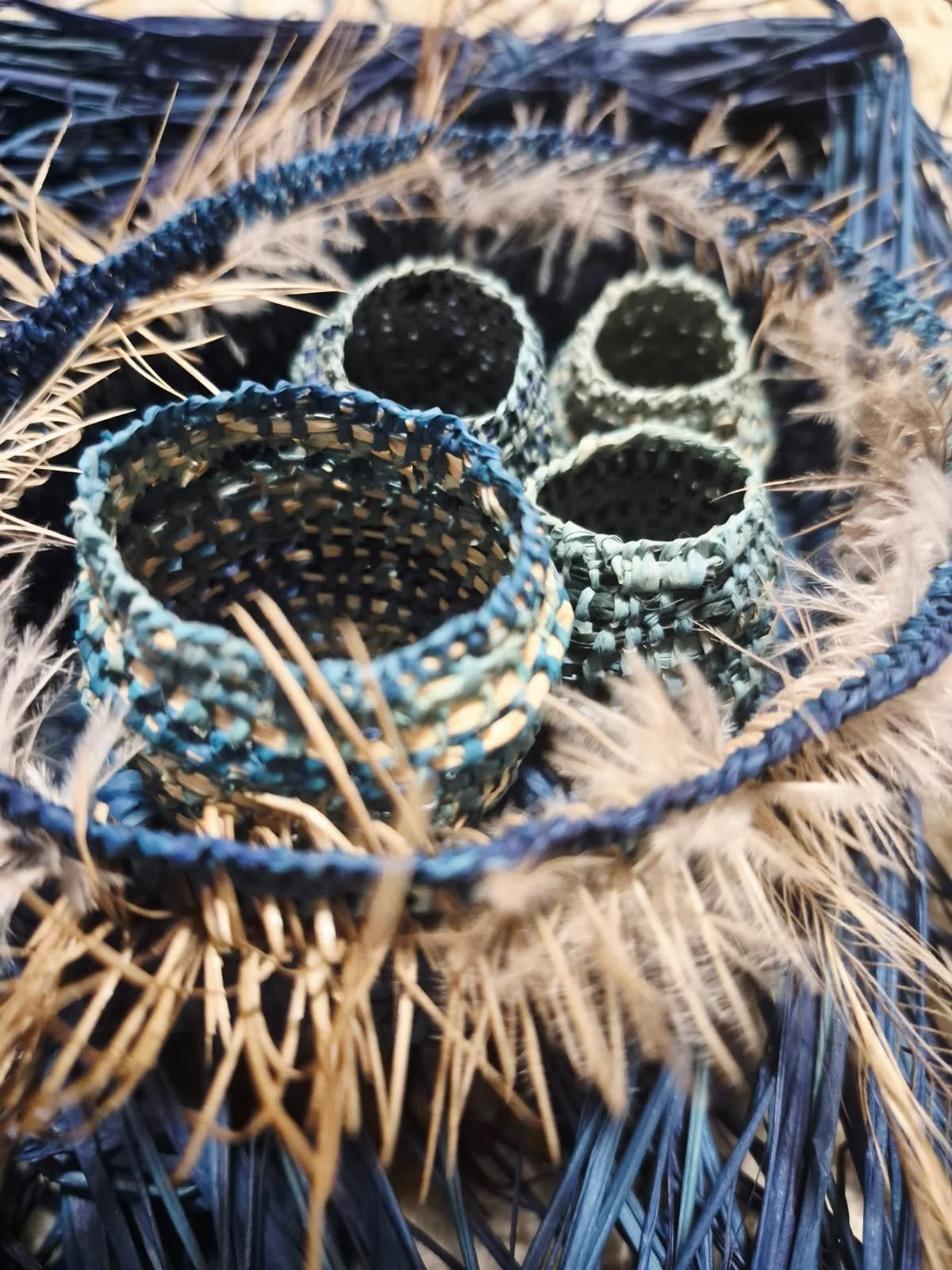 handwoven blue and tan baskets made from raffia and emu feathers by artist Melinda Solomon