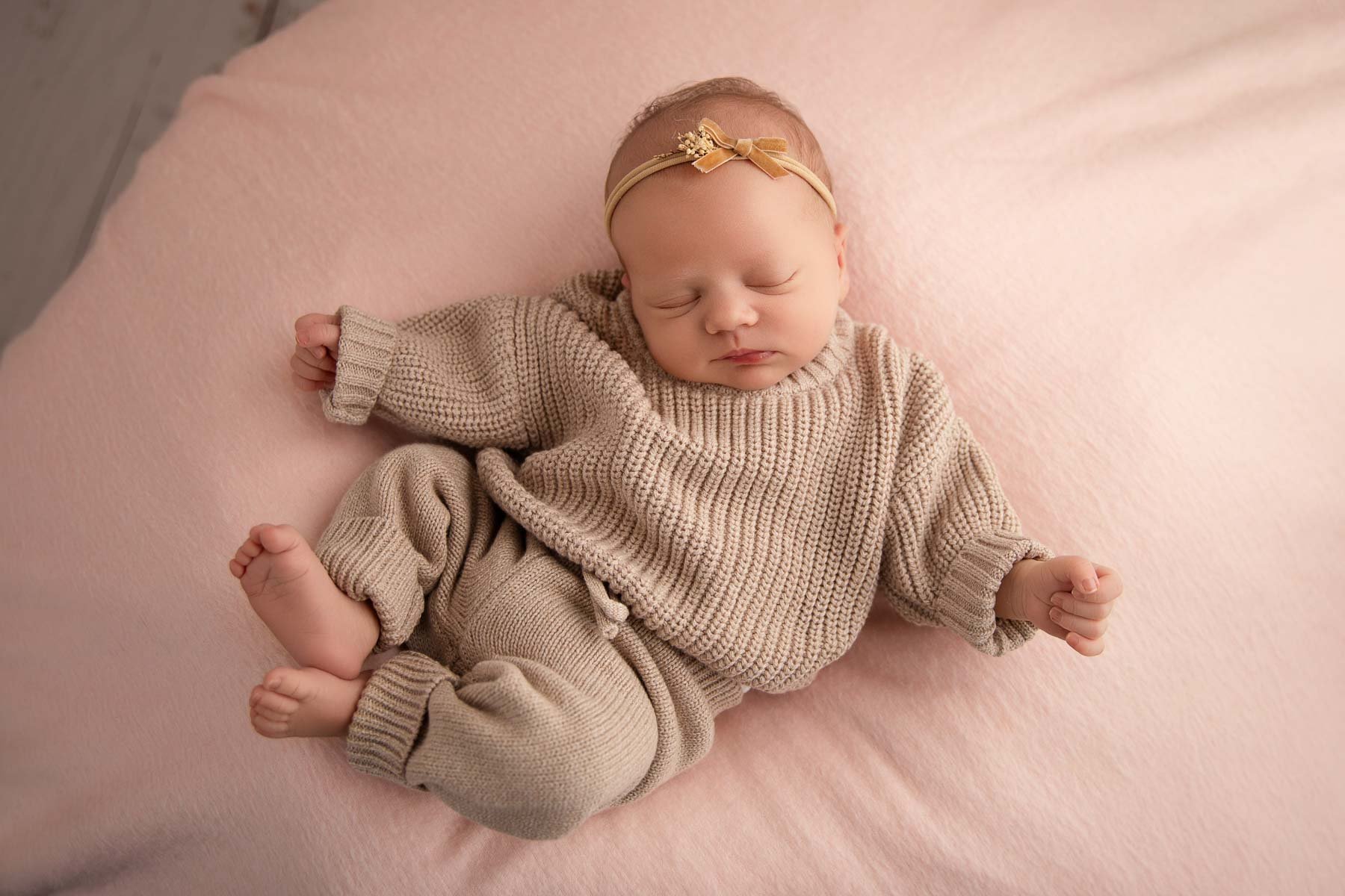 Noemie Vonthron Photography Newborn North Shore Photographer relaxed posed session baby girl wearing knit outfit sleeping on pink