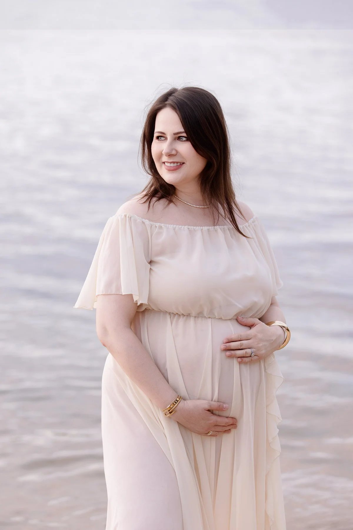 Pregnant woman in off white dress in the water at sunset North Shore Maternity photographer