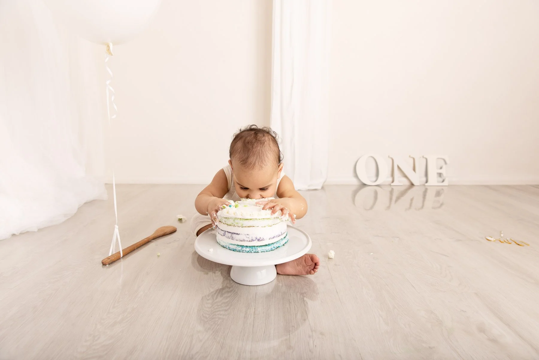 Cake smash photographer Sydney North Shore white theme baby eating the cake