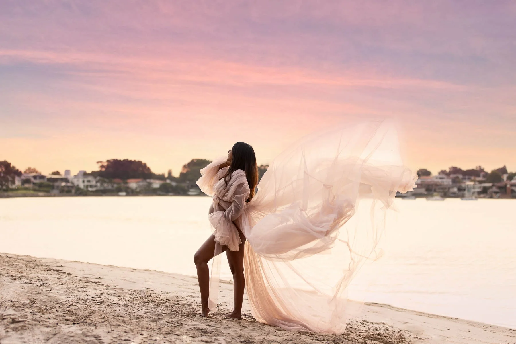 Pregnant woman in white dress in the water at sunset North Shore Maternity photographer