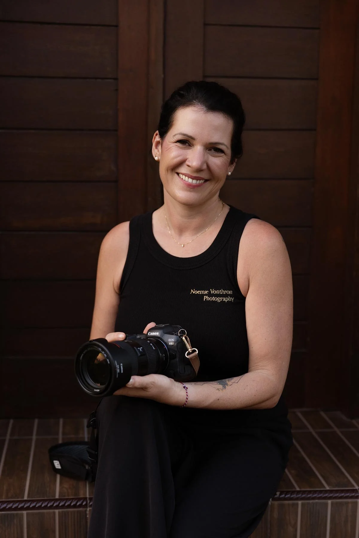 Portrait of Noemie Vonthron Photography holding her camera and smiling