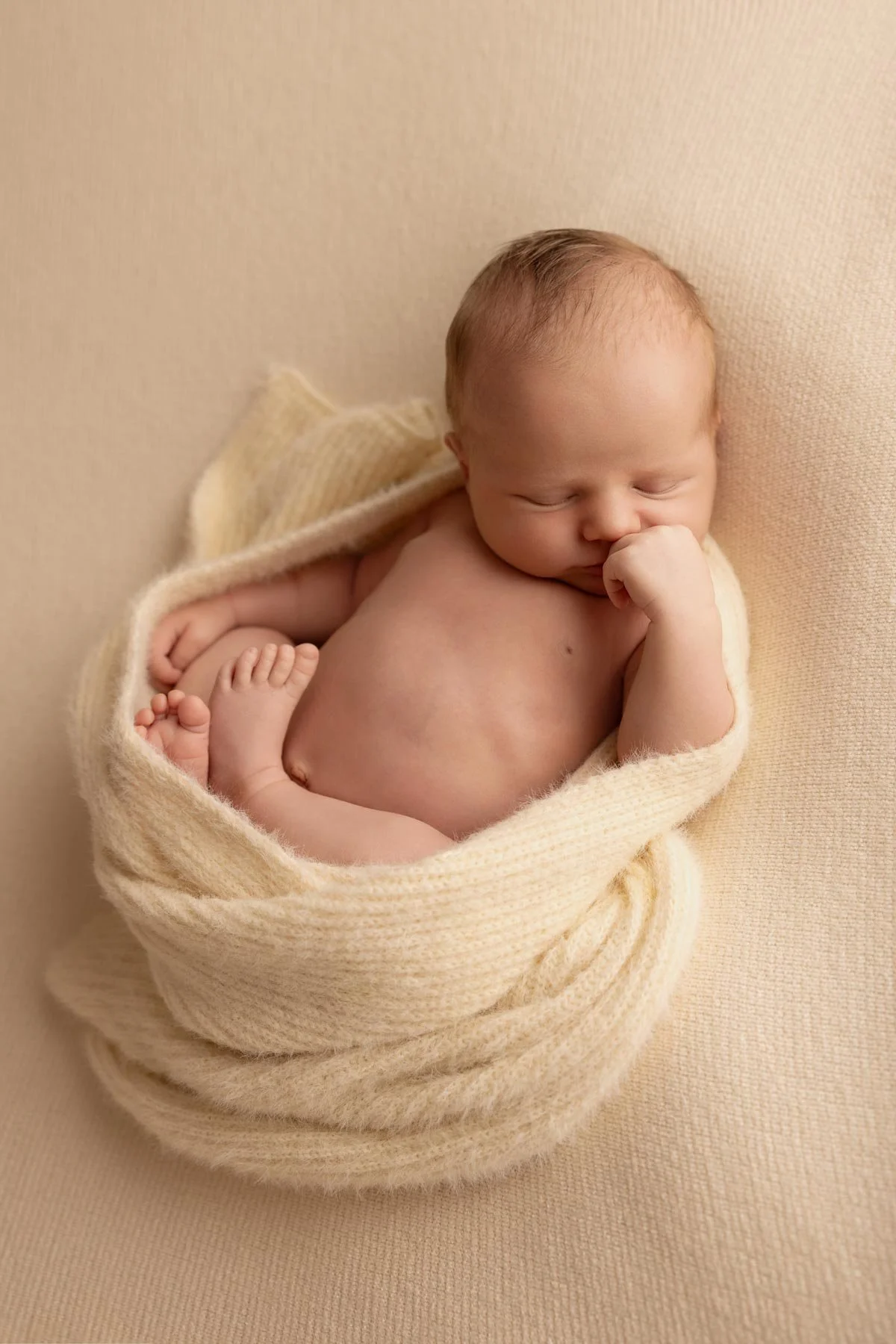 Newborn photographer Hunters Hill
Newborn laying down wrapped in a ivory wrap wearing no clothes and sleeping