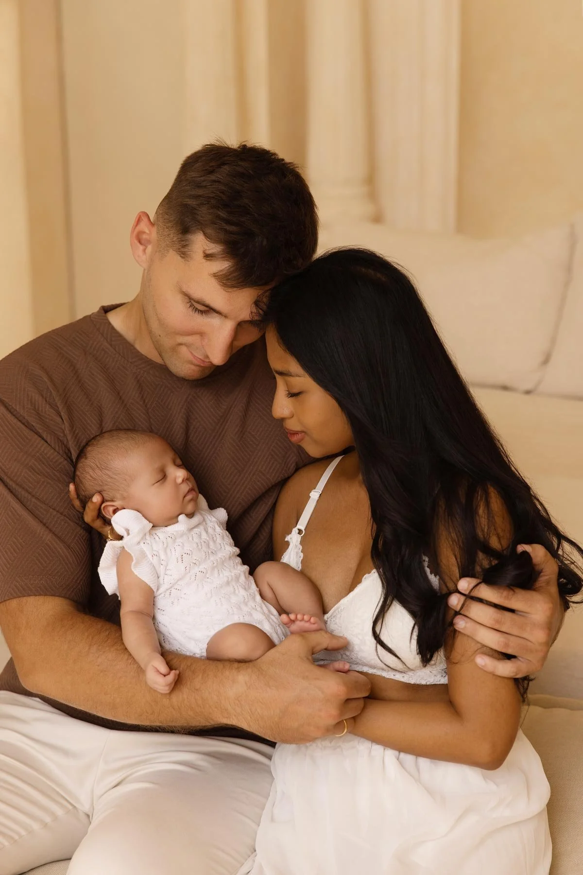 couple holding their newborn baby at home in a beautiful boho decor