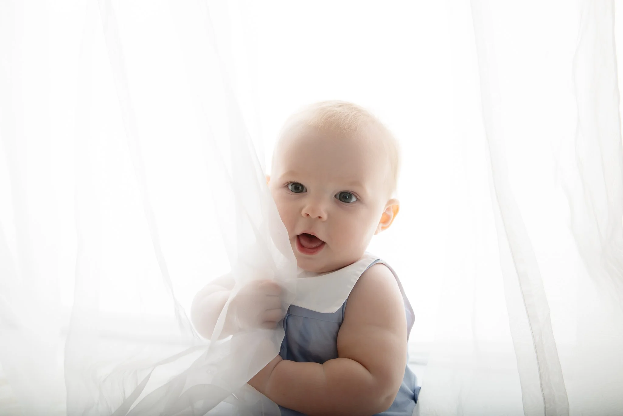 Baby photographer Sydney Inner West
baby playing with white curtains smiling