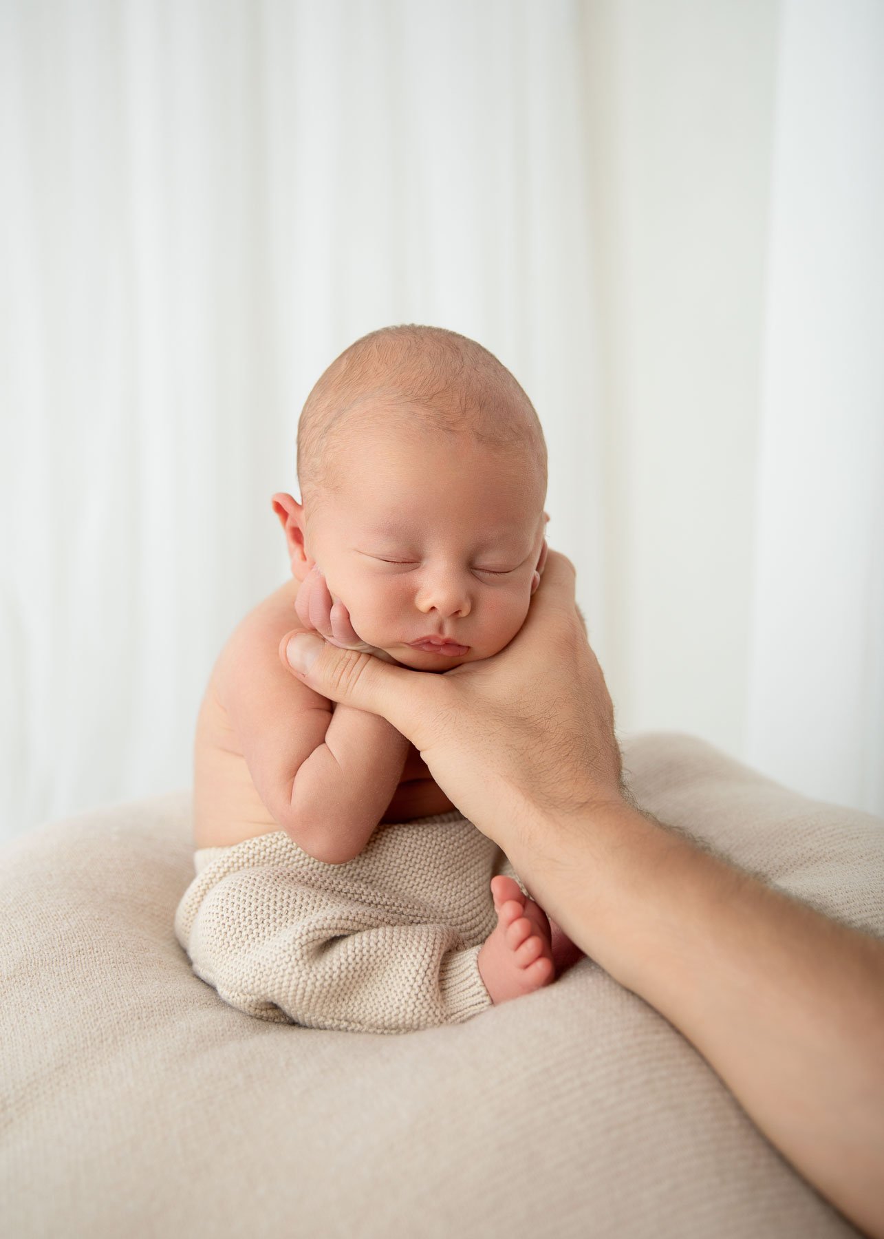 Relaxed newborn session, baby sitting held by his dad, Noemie Vonthron Photography Newborn North Shore Photographer