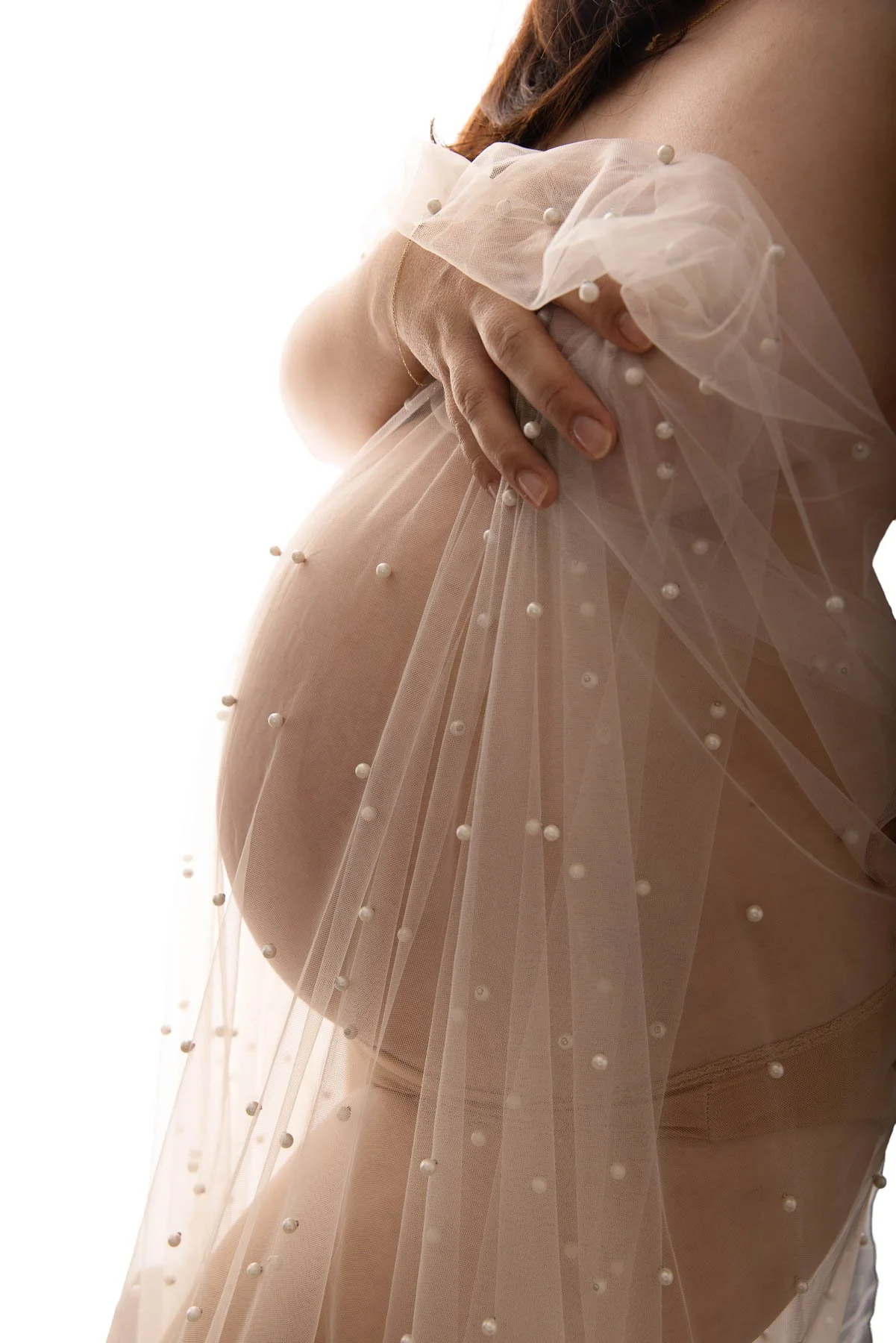 pregnant belly with a tulle sheer neutral colours