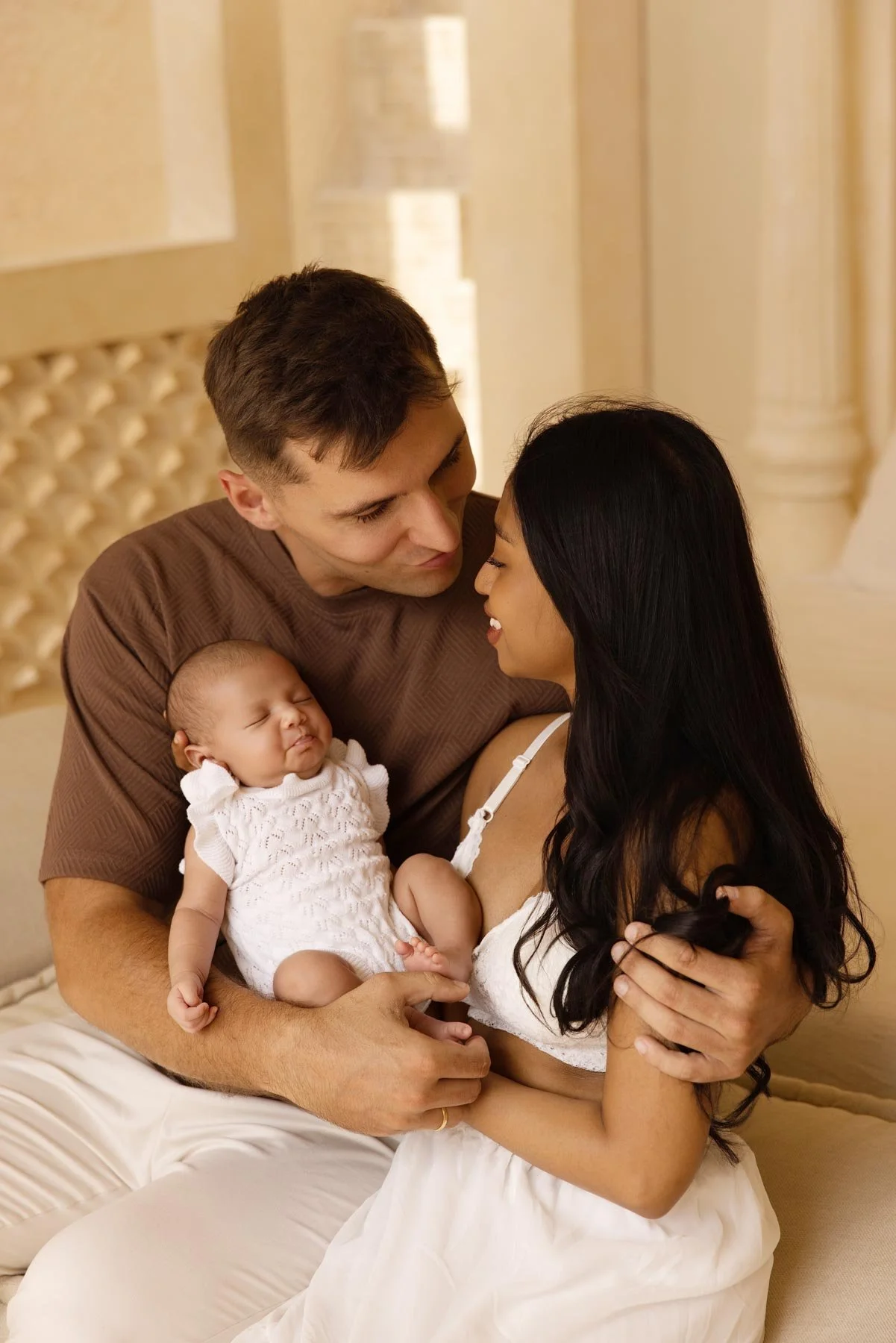 couple holding their newborn baby at home in a beautiful boho decor